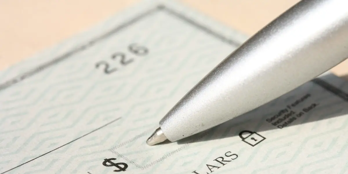 Payroll cheque and pen — payroll processing and tax filings